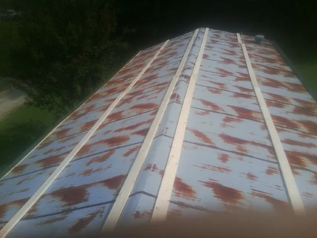 Rusted metal roof panels with new wood purlins before replacement — Storm Damage Roof Repair in Willis by Roofing Brothers